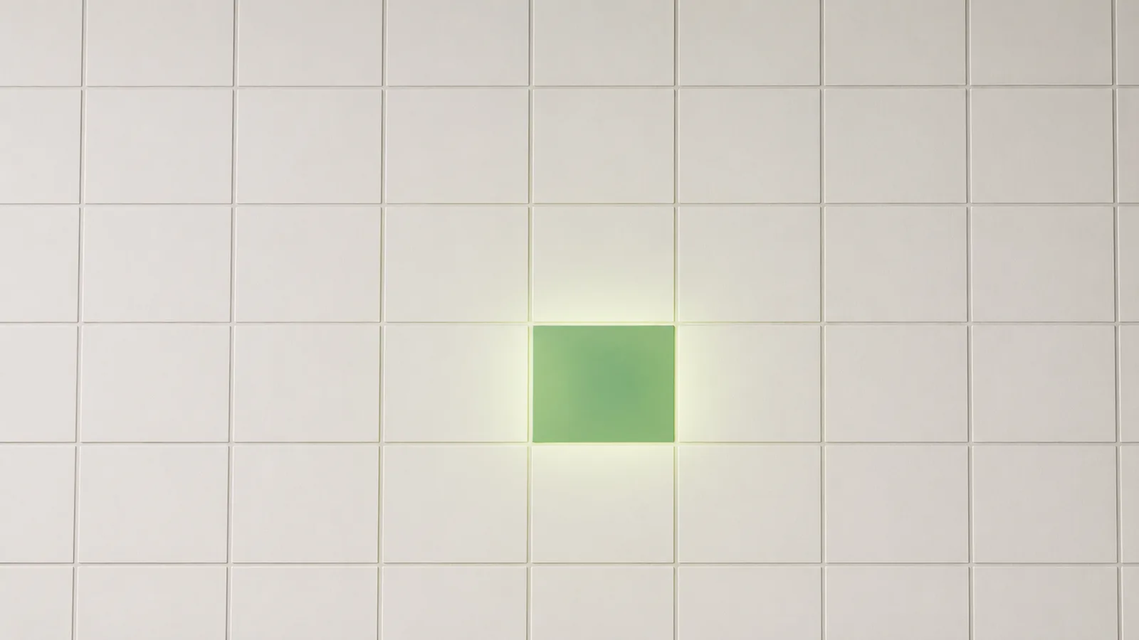 A grid of pale empty square cells, like a spreadsheet, with a single cell near the center filled solid green and glowing softly onto its neighbours.